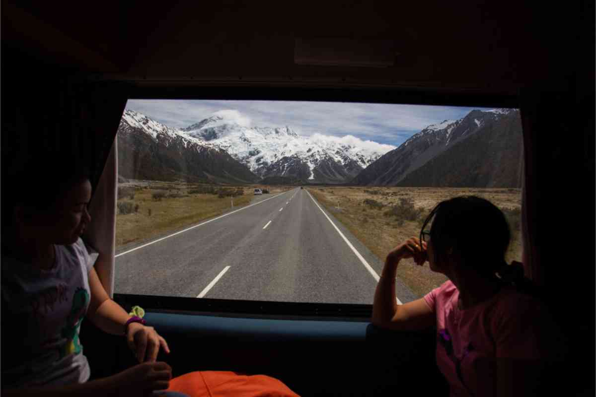 Tourist looking outside the window of their campervan in New Zealand