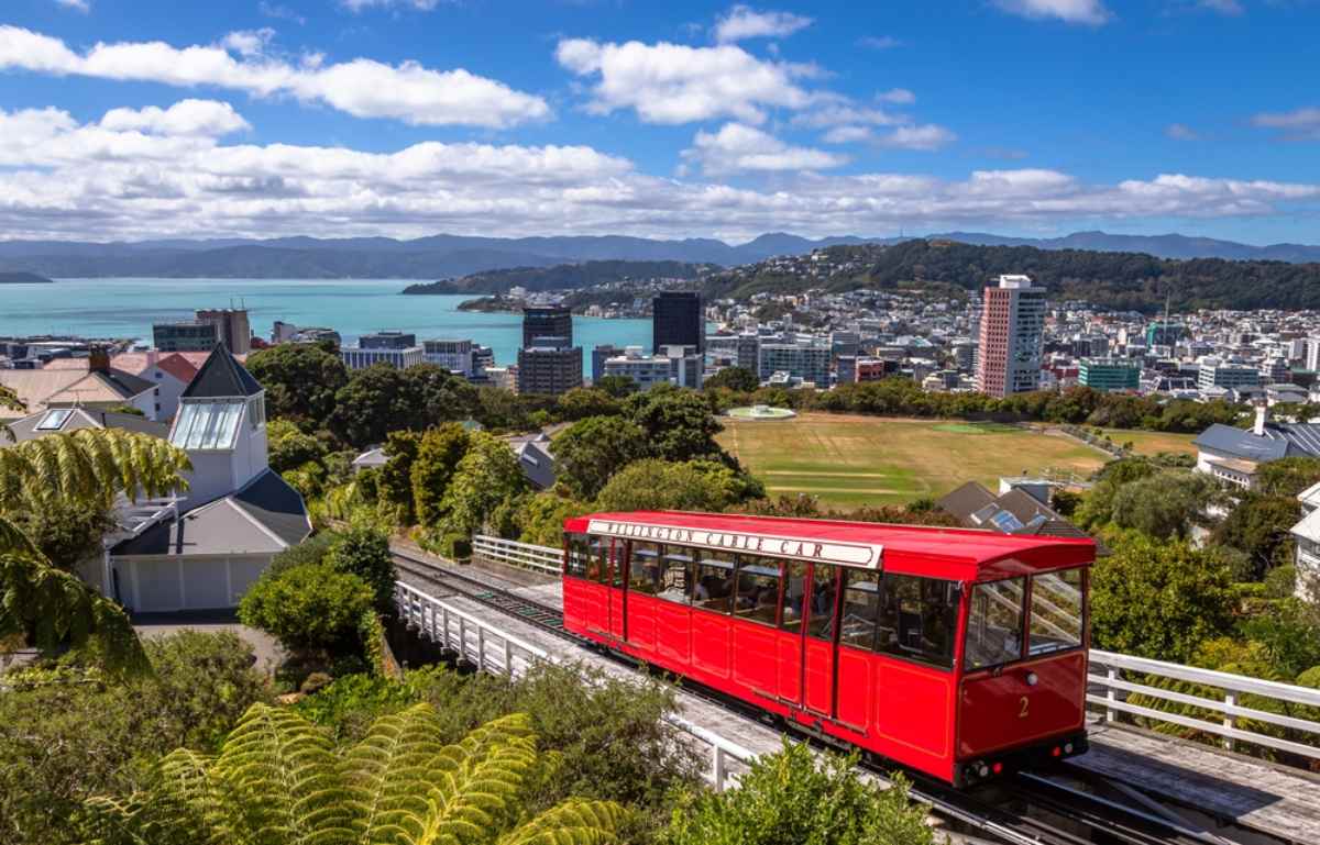 Red tram of Wellington with city views on a sunny day
