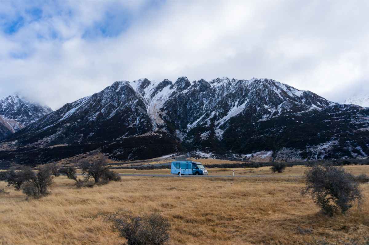 Motorhome on the road in the middle of a stunning landscape in NZ